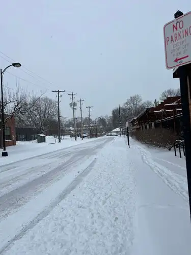 Snow blankets the street in a serene, silent hush.